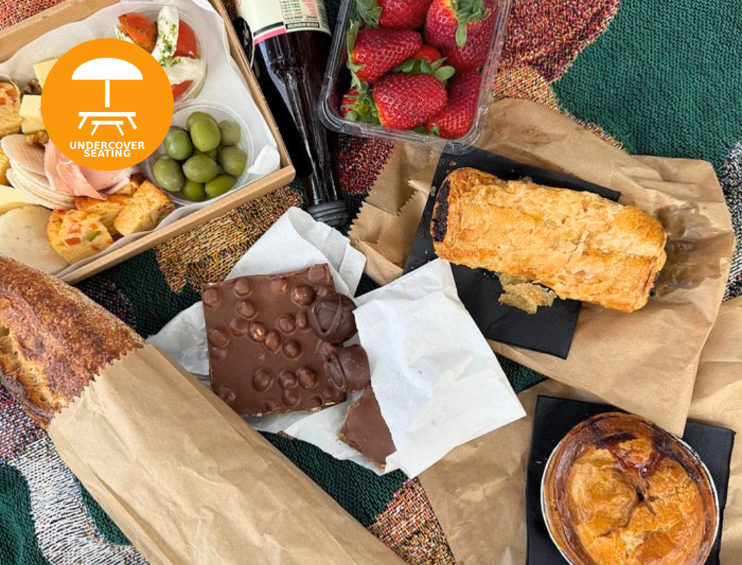 Assorted food items including chocolate bars, bread, and fruits on a table with 'Undercover' logo.